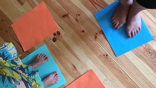 Füße auf bunten Matten, fotografiert von Catrin Otto